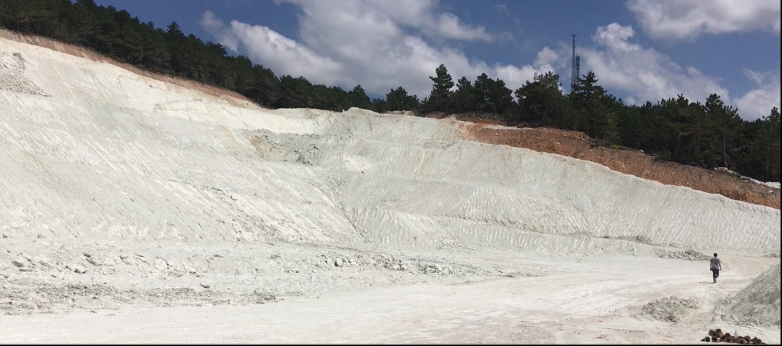Mineral quarry hillside showing layered bentonite deposits